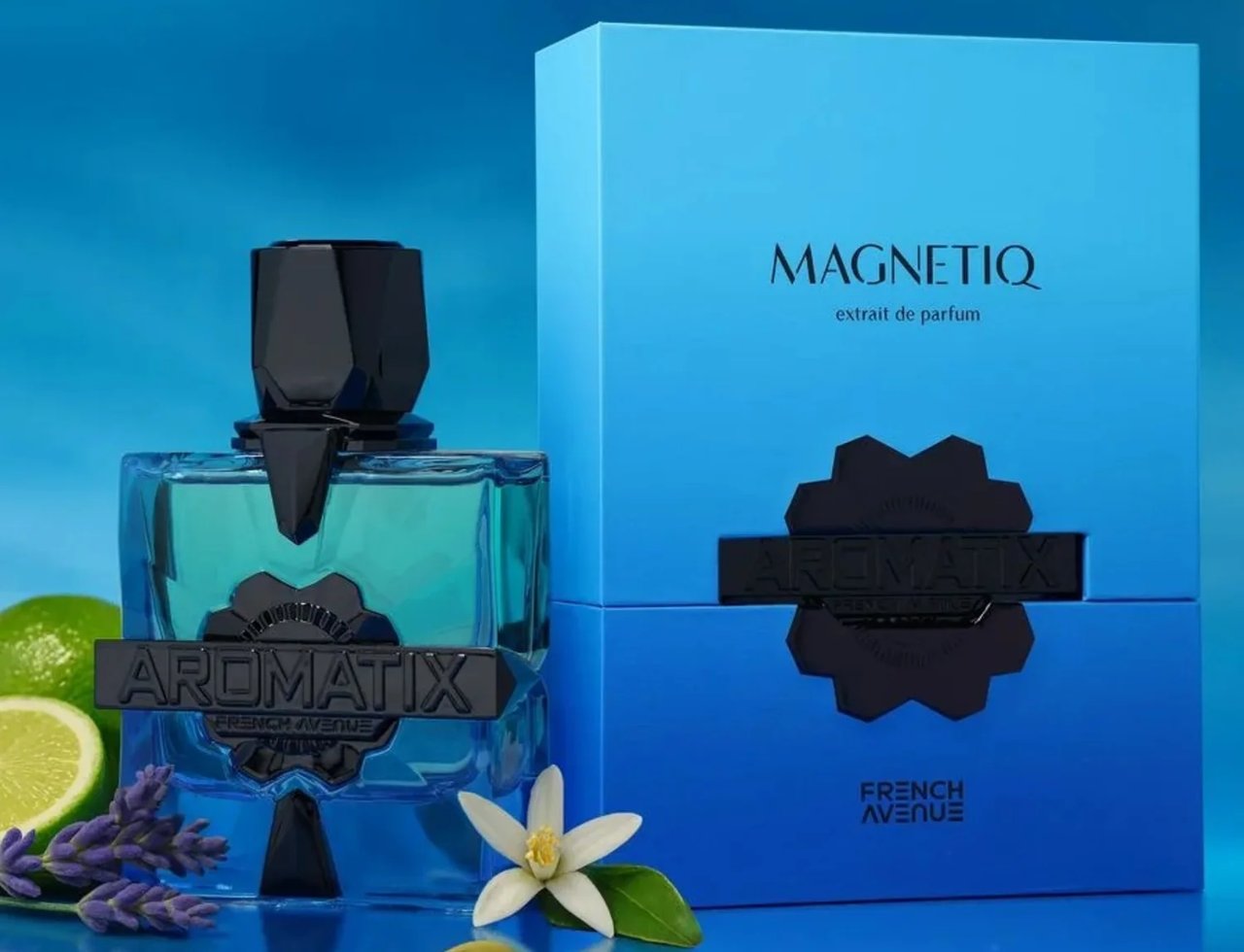 French Avenue Aromatix Magnetiq 100ml — Blue glass perfume bottle with black geometric cap, next to a blue gradient box. Lime, lavender, cardamom, and a white flower are arranged around the bottle.