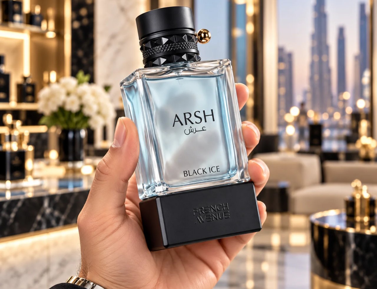French Avenue Arsh Black Ice — Hand holding a clear glass perfume bottle with a black studded cap and gold accent, against a blurred luxury interior background with city skyline view.