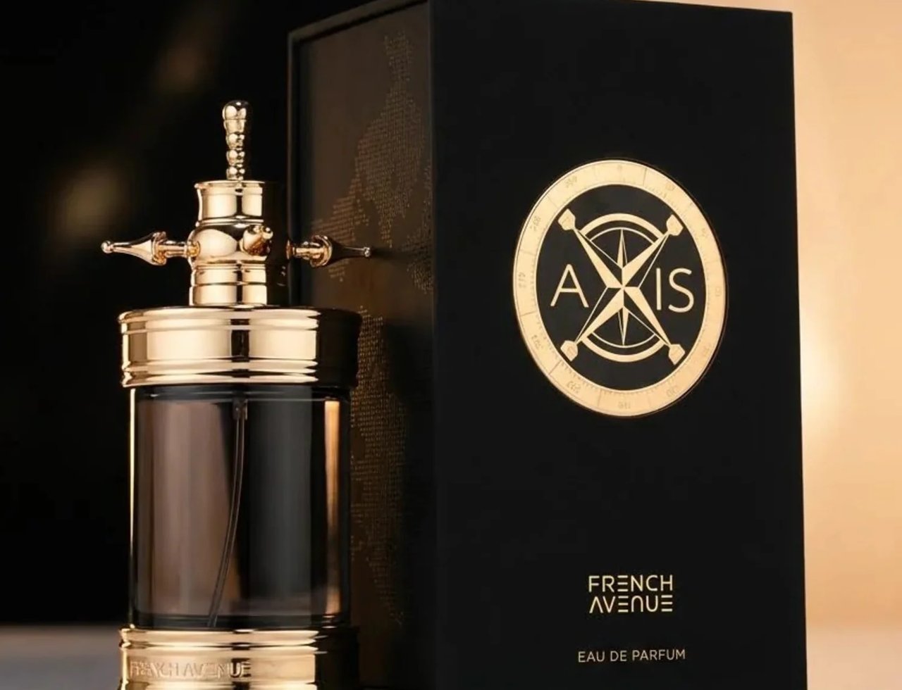 French Avenue Axis by French Avenue 100ml — A luxurious black box with a gold compass logo stands next to a dark glass perfume bottle with an ornate gold atomizer and base. | French Avenue Axis by French Avenue 100ml — Kotak hitam mewah dengan logo kompas emas berdiri di sebelah botol minyak wangi kaca gelap dengan
