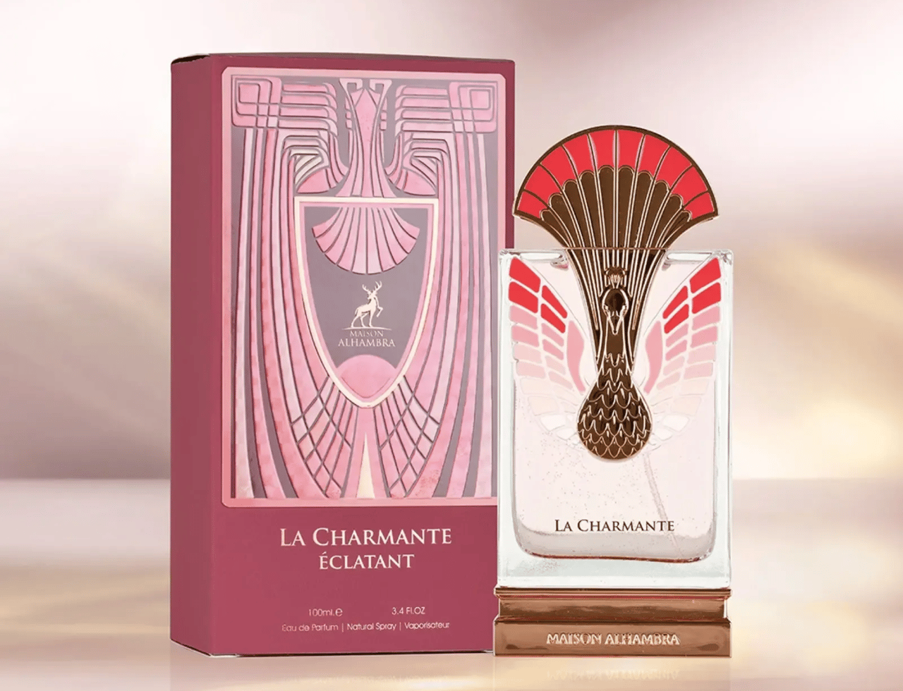 Maison Alhambra La Charmante Eclatant — Pink art deco box and ornate gold and red peacock-feathered perfume bottle with gold base