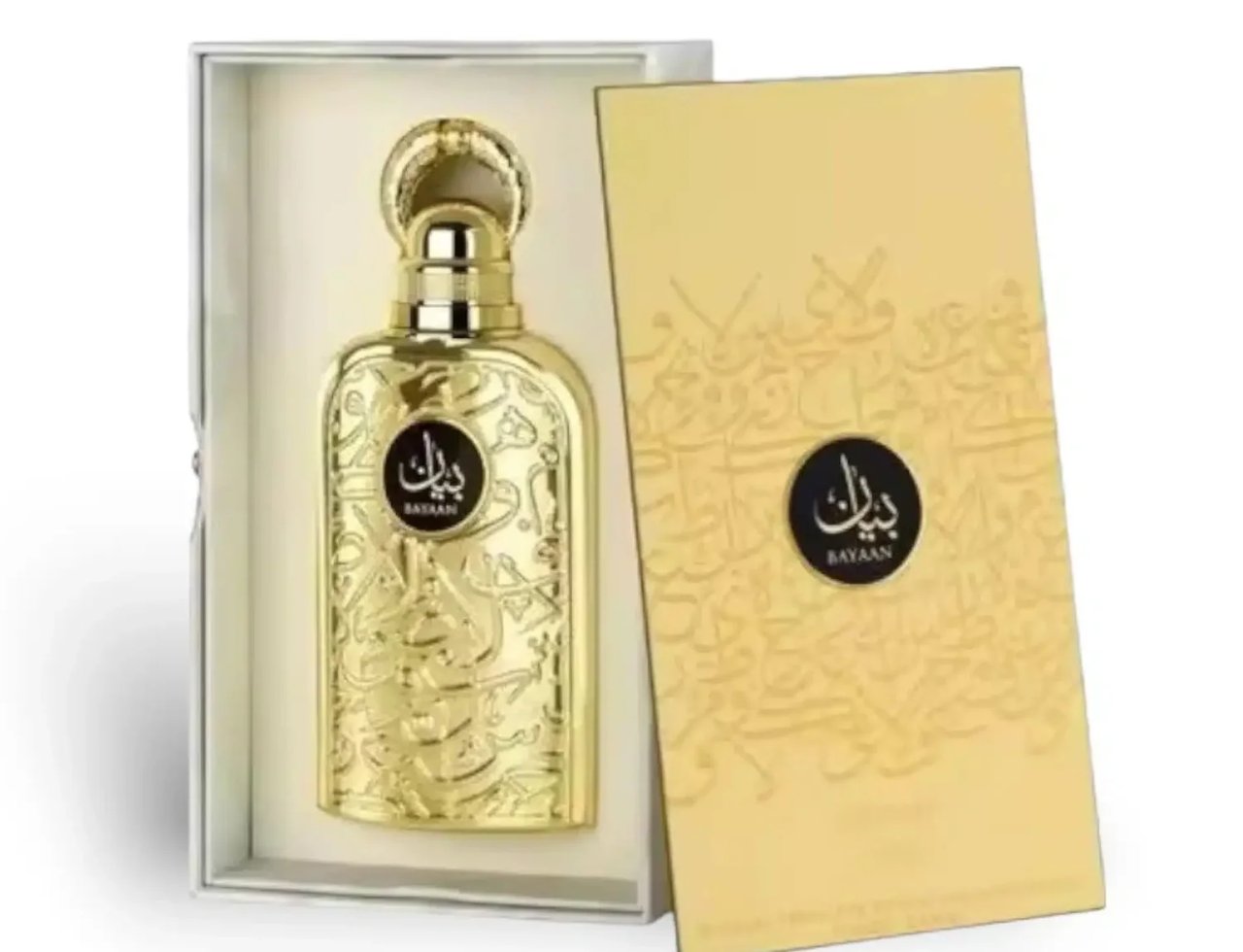 Lattafa Bayaan Eau De Parfum 100ml by Lattafa — Botol wangian emas berukir dalam kotak putih, dengan penutup emas berkilat dan kotak luar berwarna emas dengan tulisan Arab