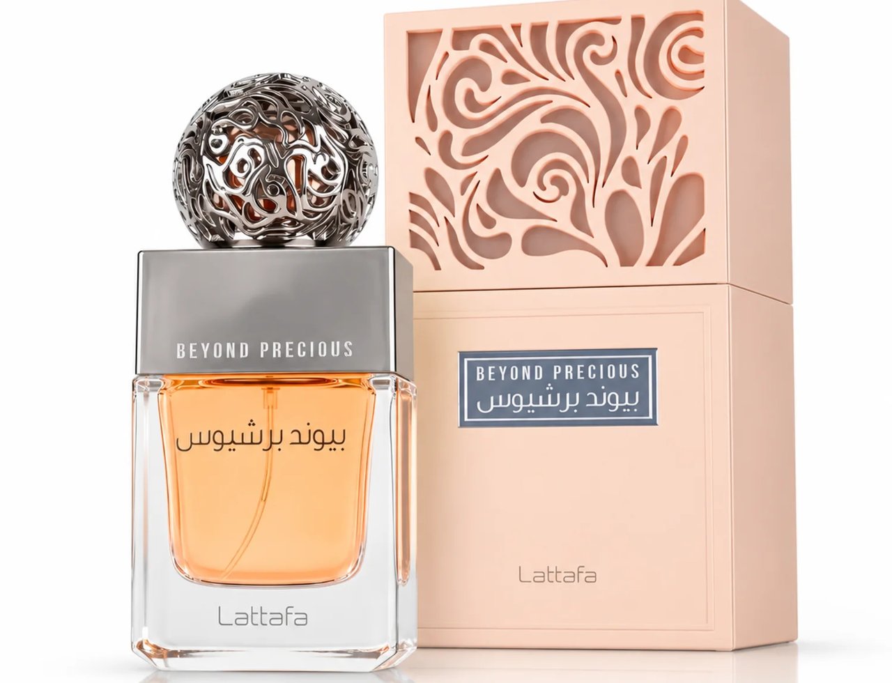 Lattafa Beyond Precious by Lattafa 100ml EDP Women — Botol minyak wangi kaca berbentuk segi empat dengan cecair oren dan penutup sfera perak berhias, bersebelahan kotak berwarna picanya dengan rekaan berlubang yang rumit.