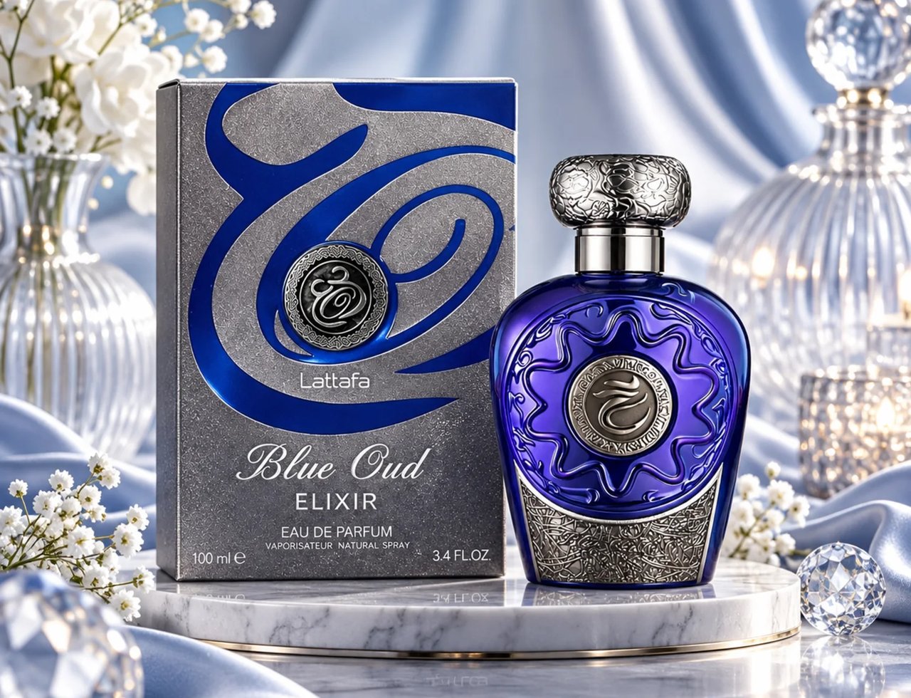 Lattafa Blue Oud Elixir — Botol minyak wangi kaca biru dengan perincian perak berukir dan kotak bertekan perak, dipamerkan di atas tapak marmar dengan langsir sutera dan bunga putih.