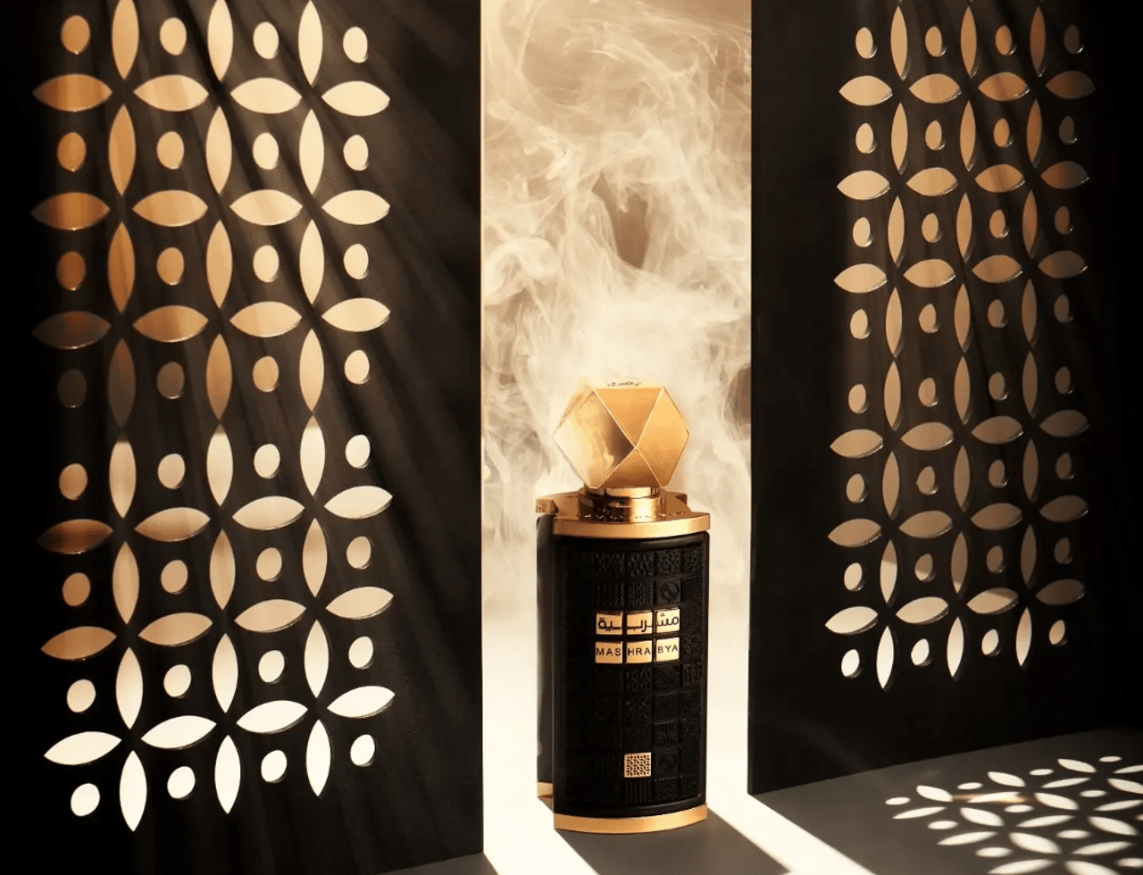 Lattafa Mashrabya by Lattafa 100ml EDP — Botol hitam bertekstur dengan aksen emas dan penutup emas geometrik, diletakkan di antara skrin hitam berhias yang memancarkan cahaya dan bayangan bermotif, dengan kepulan asap naik.