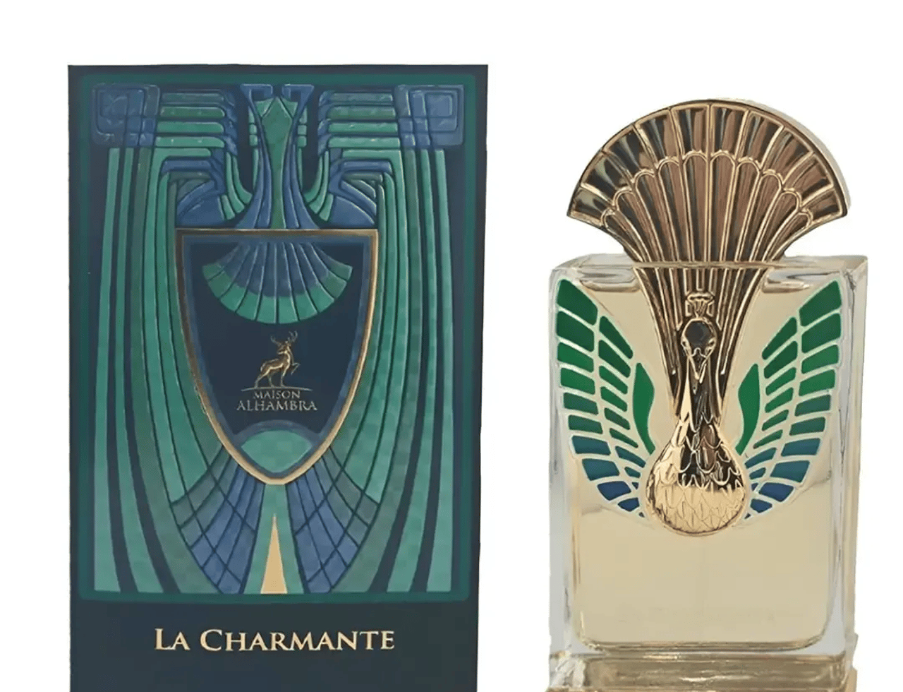 Maison Alhambra La Charmante by Maison Alhambra 100ml EDP — Botol minyak wangi dengan penutup emas ala merak dan perincian bulu hijau/biru, dipamerkan bersebelahan kotak hijau gelap padanannya dengan rekaan art deco dan lambang rusa.