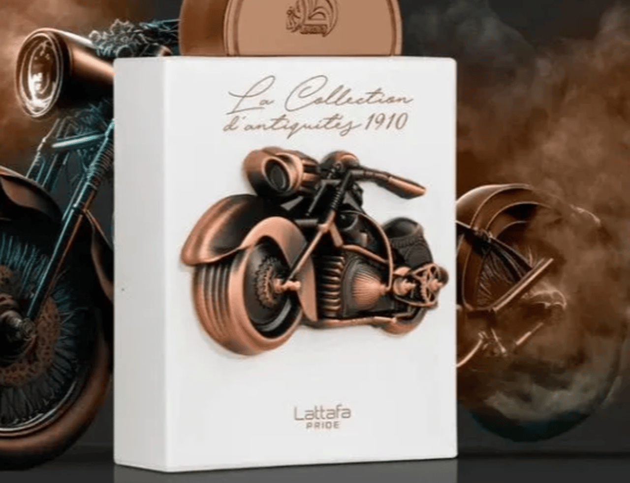 Lattafa Pride La Collection d'Antiquites 1910 (Bike) — White perfume bottle with a copper motorcycle emblem, topped with a copper cap, set against a smoky, dark background with motorcycle silhouettes.
