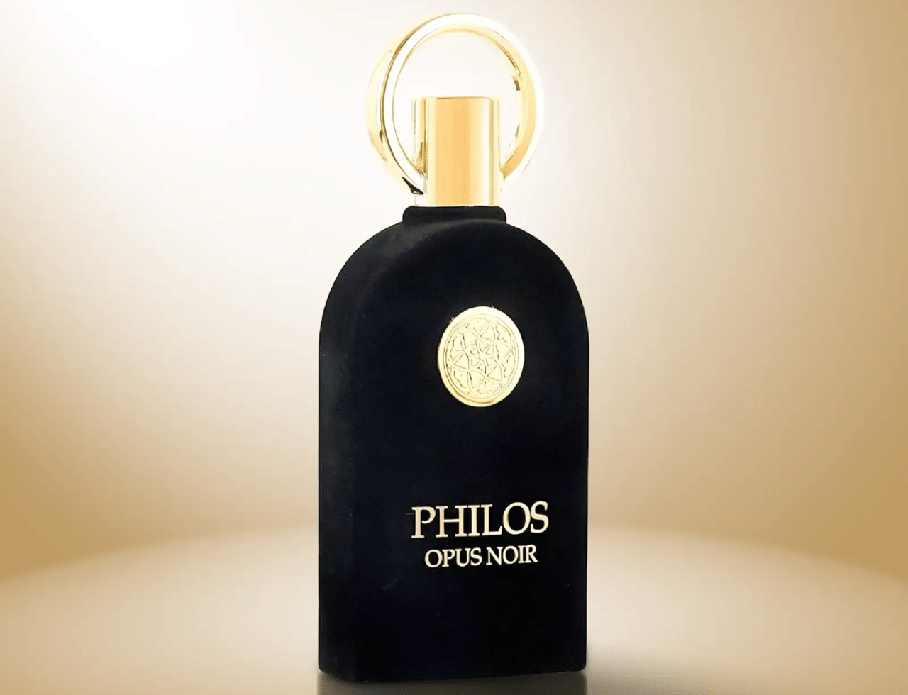 Maison Alhambra Philos Opus Noir — Black velvet perfume bottle with gold accents and a circular emblem on a gradient background.