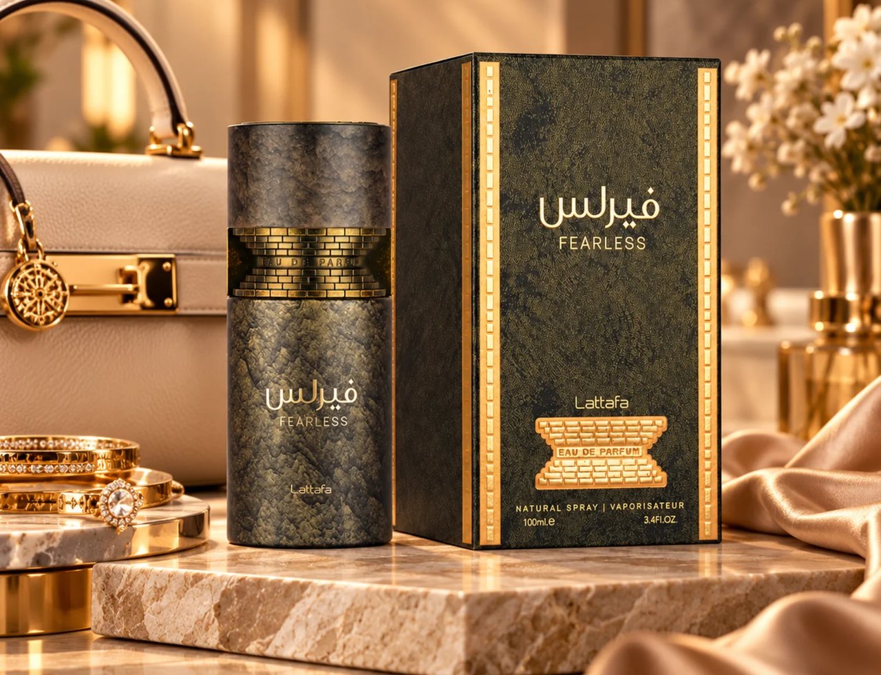 Lattafa Fearless oleh Lattafa 100ml EDP Lelaki — Botol minyak wangi Lattafa Fearless dan kotak dipamerkan di atas permukaan marmar, dengan beg tangan krim dan gelang emas di latar belakang.