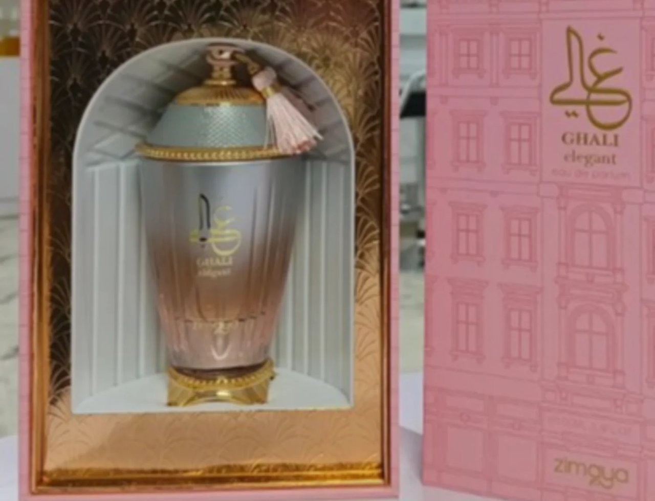 Zimaya Ghali Elegant Eau De Parfum — Botol wangian dalam kotak hadiah merah jambu dengan corak bangunan, penutup emas dan perincian beropol
