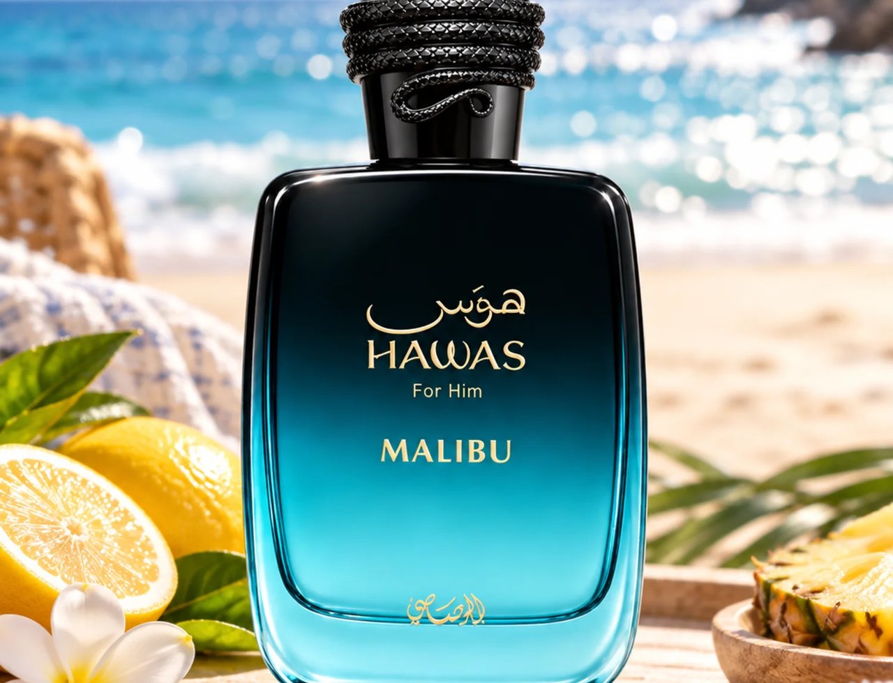 RASASI Hawas Malibu by Rasasi 100ml EDP — Botol minyak wangi biru gelap gradien yang ramping dengan tulisan Arab emas dan teks "HAWAS For Him MALIBU", diletakkan di atas kayu bersama lemon, bunga plumeria, dan nenas, dengan latar belakang pantai dan laut yang kabur.
