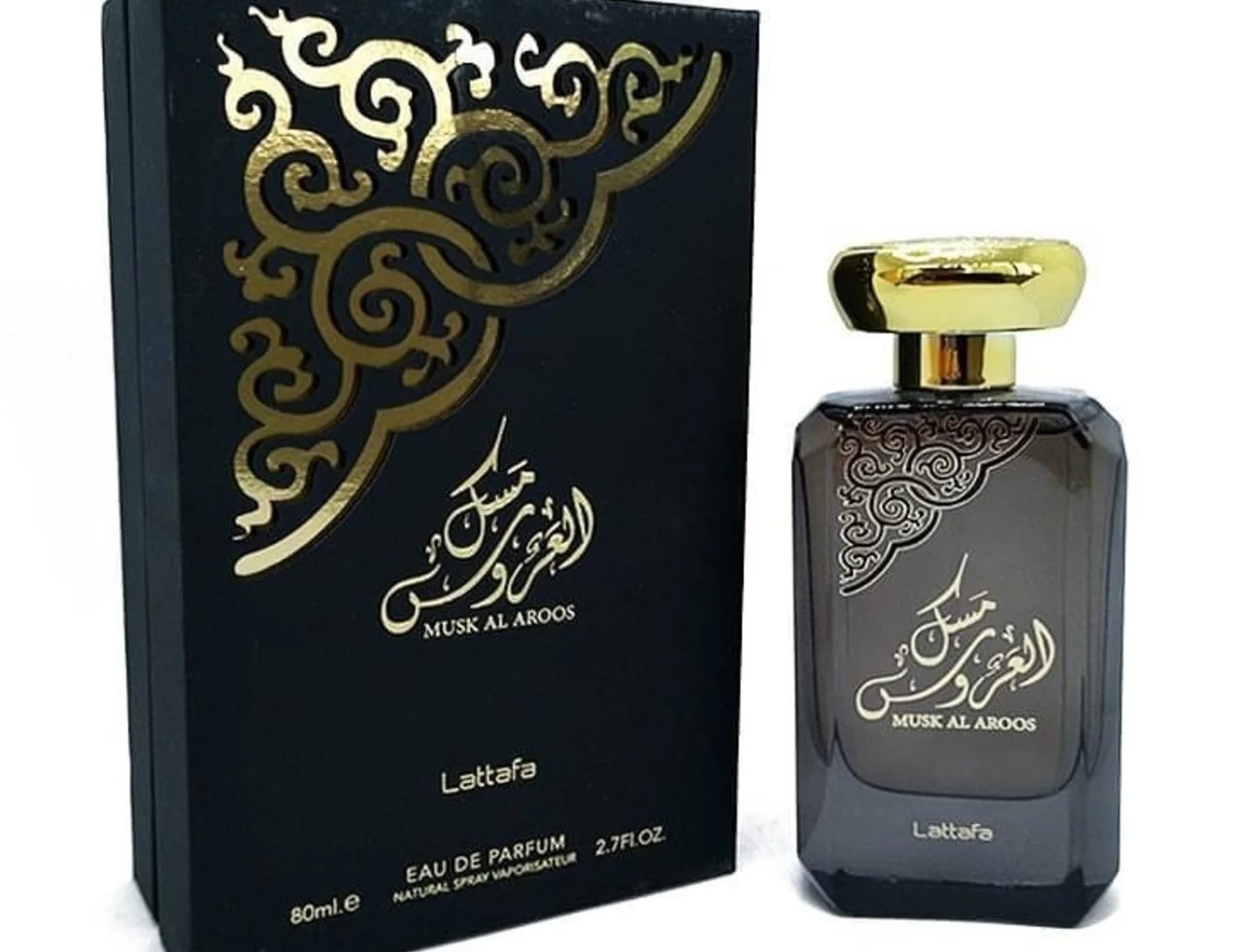 Lattafa Musk Al Aroos by Lattafa 80ml EDP — Kotak hitam berhias corak emas dan botol kaca gelap dengan penutup emas berkilat, kedua-duanya memaparkan tulisan Arab dan nama produk.