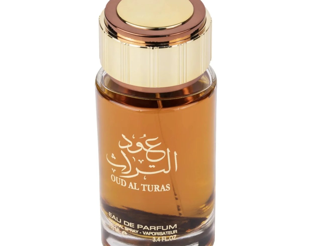 Ard Al Zaafaran Oud Al Turas 100ml by Ard Al Zaafaran — A clear glass bottle of amber-colored perfume with gold and bronze cap, featuring Arabic script and "OUD AL TURAS" text. | Ard Al Zaafaran Oud Al Turas 100ml oleh Ard Al Zaafaran — Botol kaca jernih berisi minyak wangi berwarna ambar dengan penutup emas dan