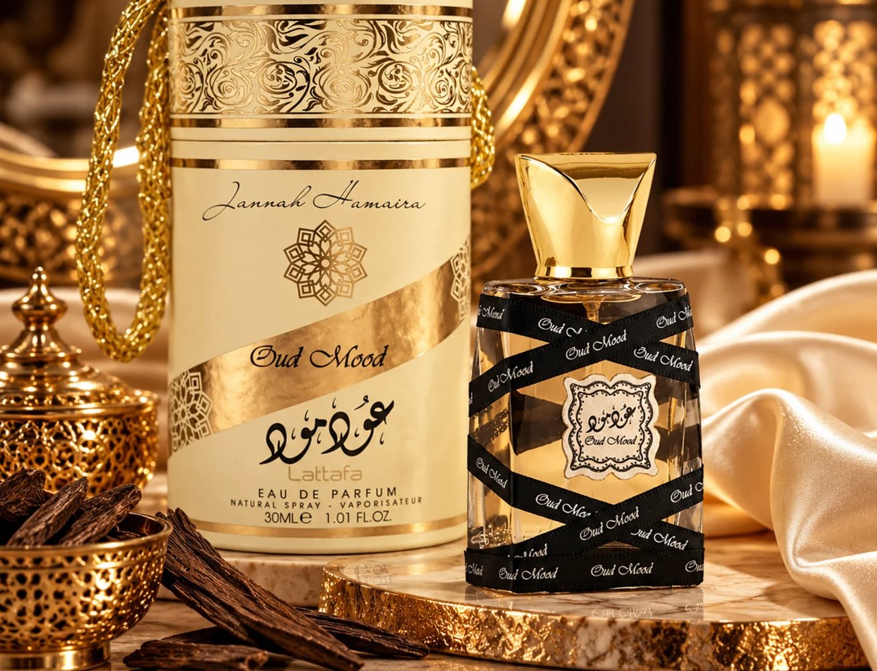 Lattafa Oud Mood 30ml oleh Lattafa EDP Unisex — Kotak silinder tinggi berwarna krim dengan corak emas berukir dan pemegang rantai emas, bersebelahan botol minyak wangi kaca jernih bertutup emas, dibalut reben hitam tertulis 'Oud Mood'.
