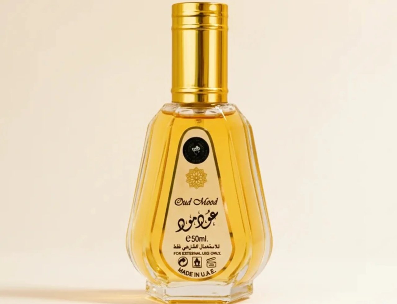Ard Al Zaafaran Oud Mood oleh Ard Al Zaafaran 50ml EDP Unisex — Botol minyak wangi kaca jernih reka bentuk berlekuk dengan penutup emas, berisi cecair keemasan. Label tertera "Oud Mood" dalam Bahasa Inggeris dan skrip Arab, dengan "e 50ml" dan "MADE IN U.A.E."