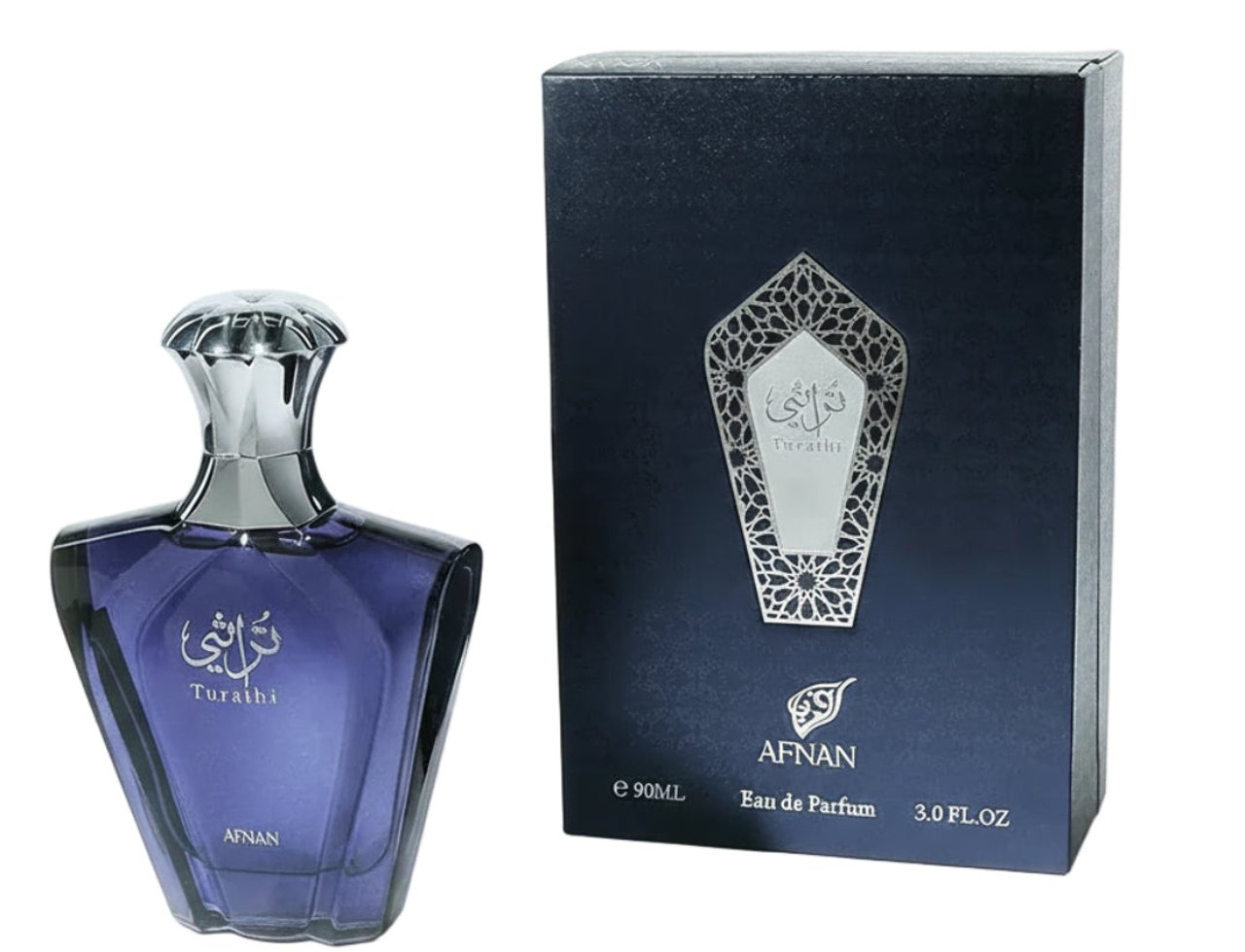 Afnan Turathi Blue by Afnan 90ml EDP for Man — Botol kaca biru gelap berbentuk unik dengan penutup perak berkilat, diletakkan di sebelah kotak kadbod biru gelap dengan reka bentuk perak.