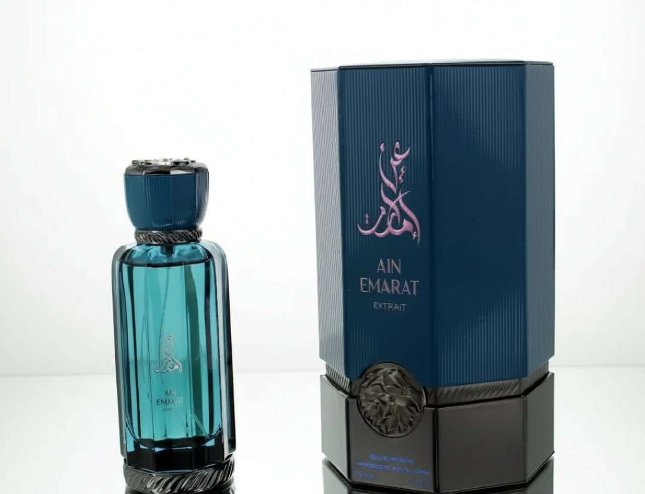 Al Wataniah Ain Emarat Al Wataniah Eternal Extrait Perfume 100ml — Botol kaca biru kehijauan berisi minyak wangi berdiri di sebelah kotak biru gelap bertekstur bergaris, kedua-duanya dengan logo Ain Emarat.