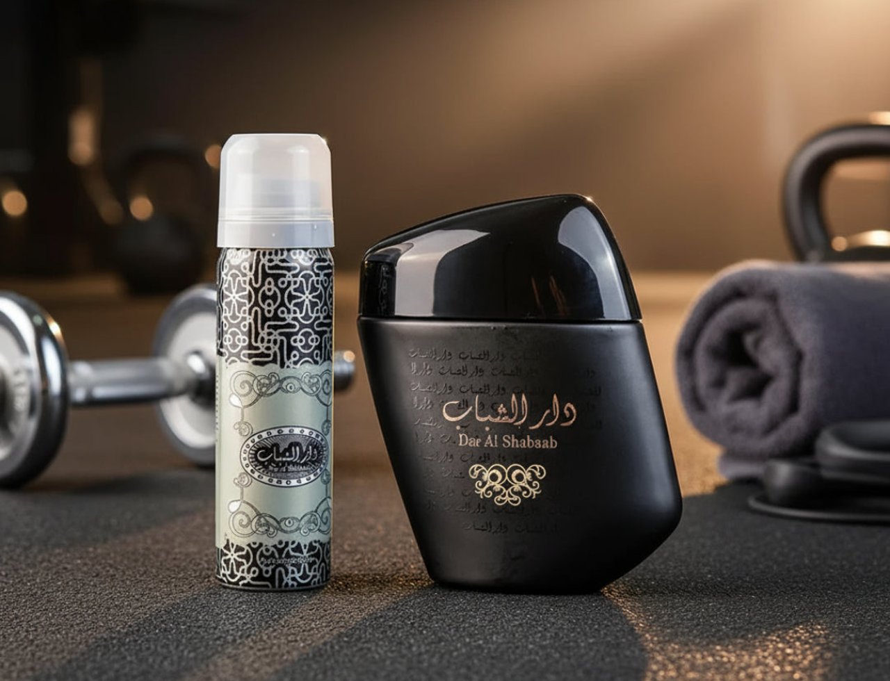 Ard Al Zaafaran Dar Al Shabaab — Two perfume bottles and a dumbbell on a gym floor with a towel and headphones