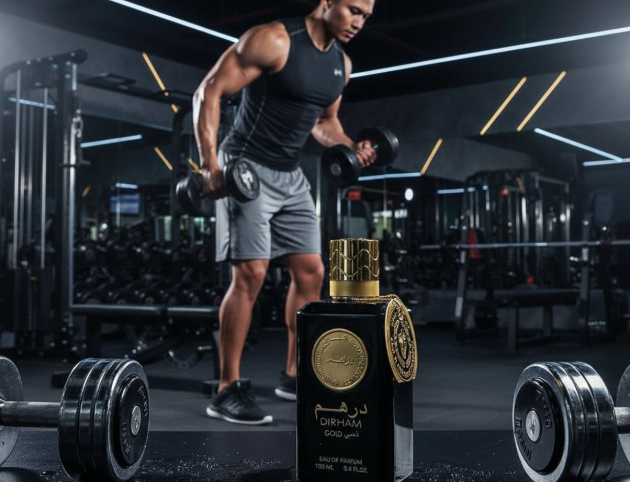 Ard Al Zaafaran Dirham Gold By Ard Al Zaafaran 100ml For Him — Botol wangian hitam dengan penutup emas terletak di atas permukaan gelap berair, dengan seorang lelaki berotot mengangkat dumbbell di gimnasium yang diterangi lampu neon di latar belakang