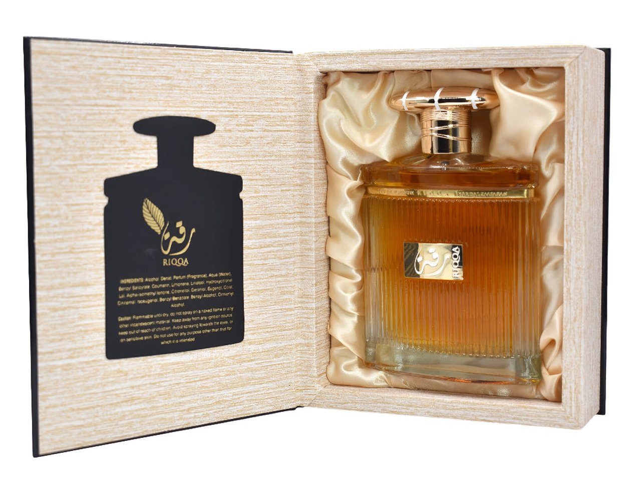 Ard Al Zaafaran Riqqa by Ard Al Zaafaran 100 ml EDP Men — Botol wangian kaca berjalur berisi cecair keemasan, diletakkan di dalam kotak kayu terbuka dengan lapisan satin emas. Terdapat maklumat produk pada bahagian dalam kotak.