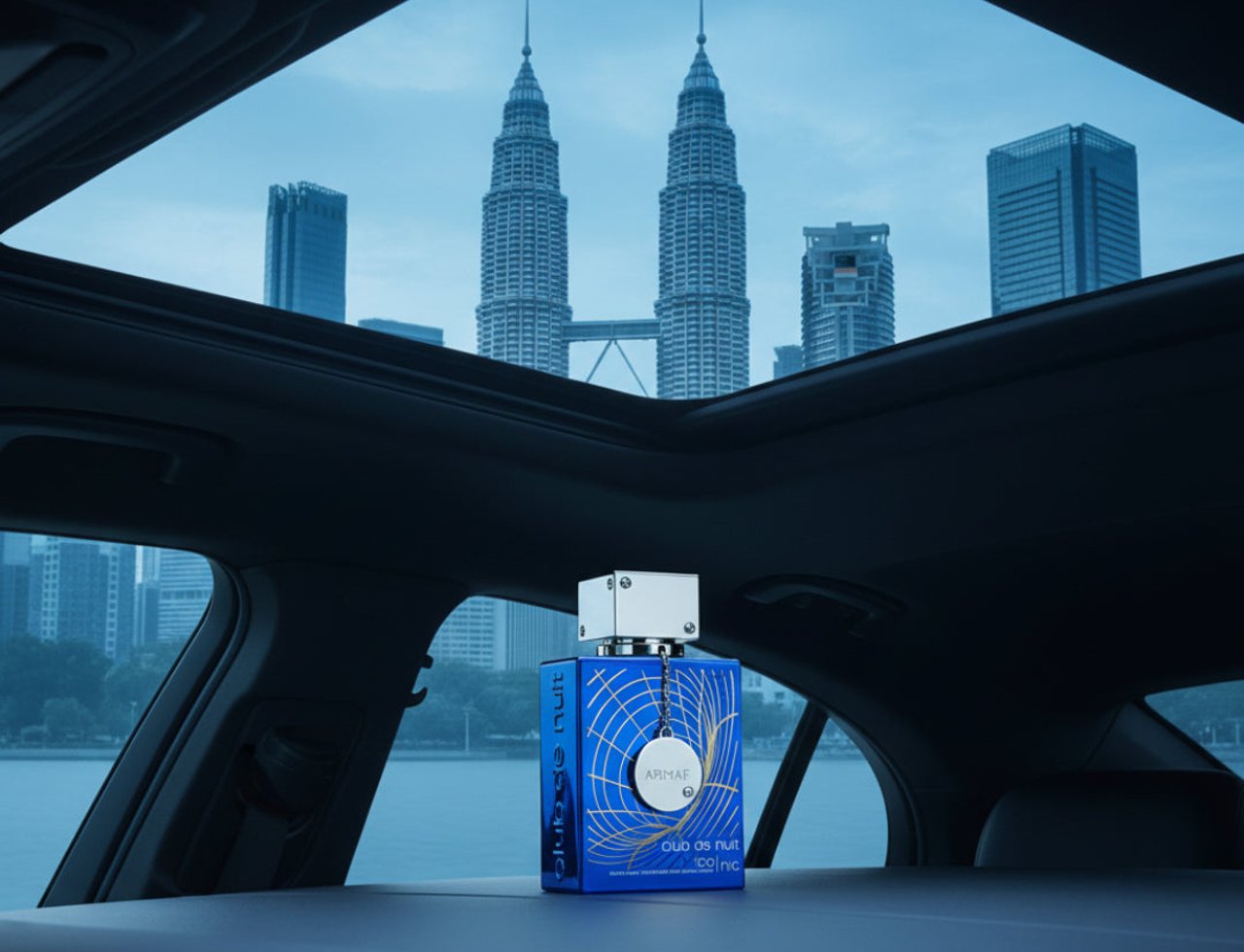 Armaf Club De Nuit Iconic 105ml EDP Men — Blue perfume bottle with silver cap sits on car dashboard with Petronas Towers