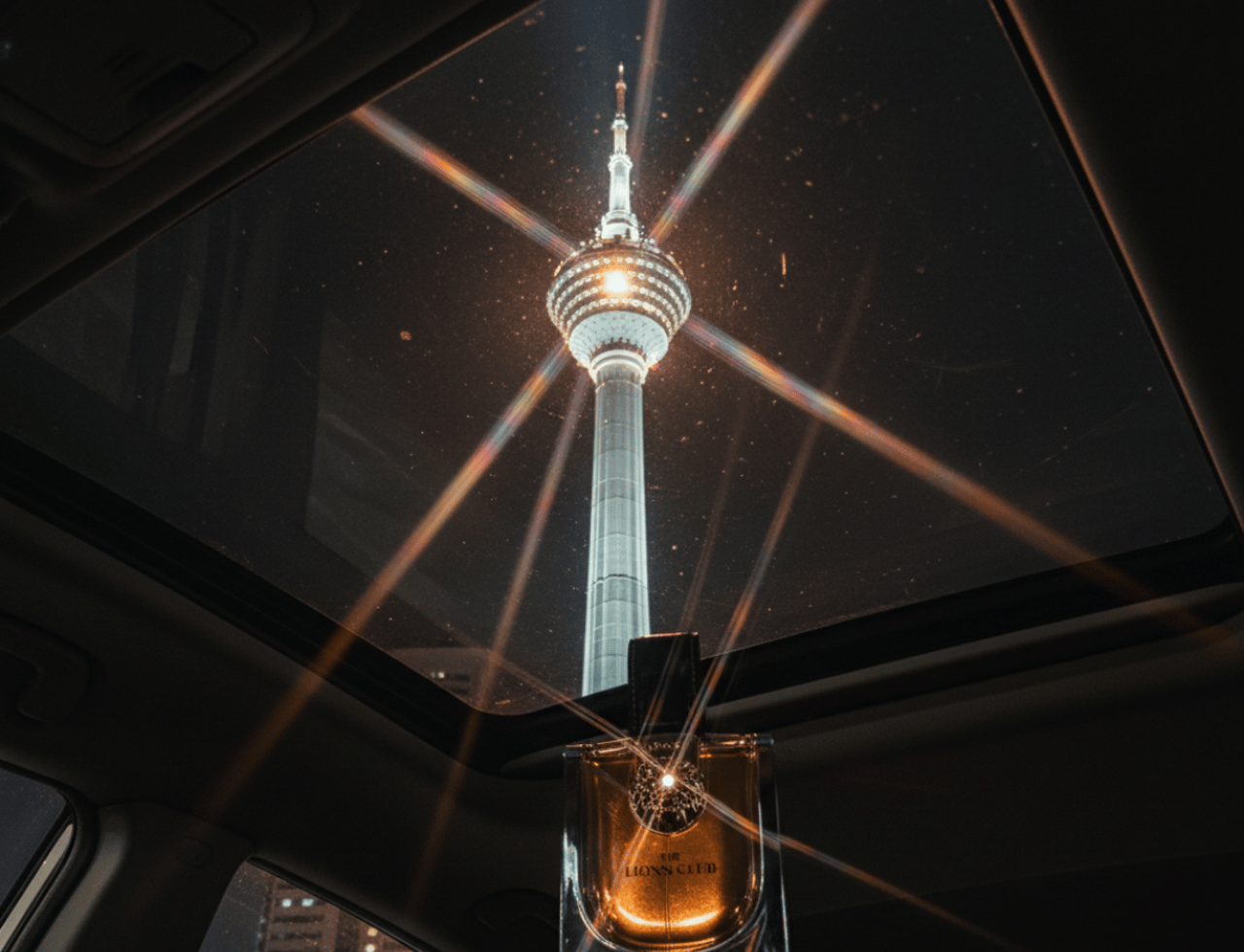 Armaf Monarque by Armaf Lions Club 100ml EDP — Perfume bottle on car sunroof with Kuala Lumpur Tower at night