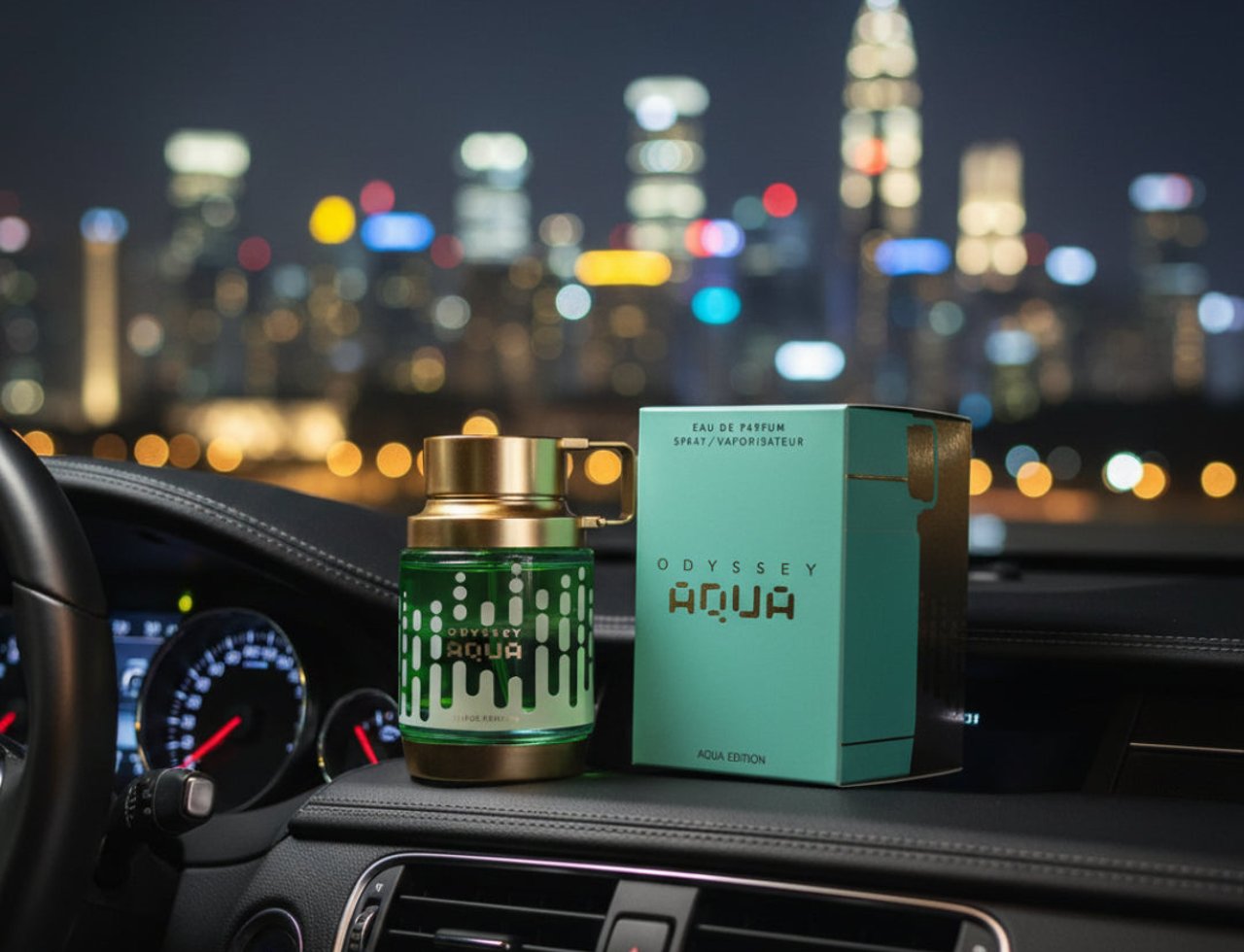 Armaf Armaf Odyssey Aqua Edition 100ml EDP Men — Botol minyak wangi hijau dengan penutup emas diletakkan di atas papan pemuka kereta malam hari, dengan latar belakang bandar yang bercahaya.