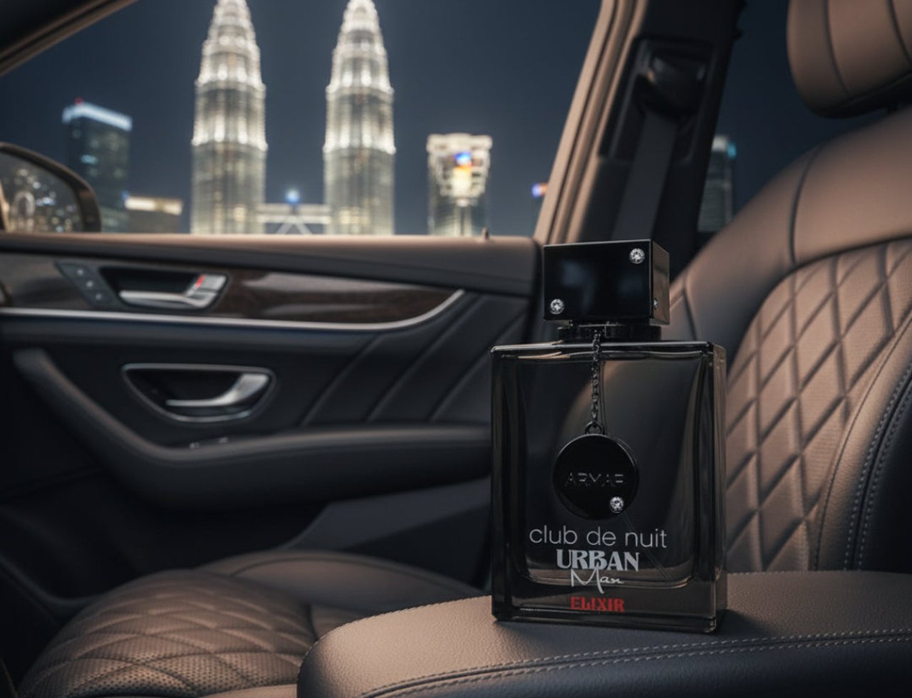 Armaf Club De Nuit Urban Elixir 105ml EDP — Botol wangian hitam diletakkan di atas tempat letak tangan kereta mewah, dengan latar belakang bangunan pencakar langit berkilauan pada waktu malam.