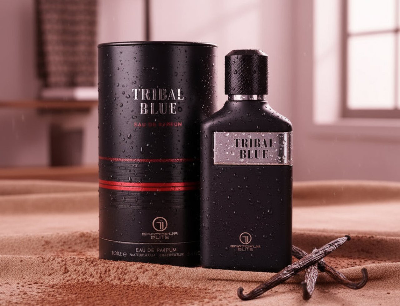 Grandeur Tribal Blue Man by Grandeur 100ml EDP Men — Botol minyak wangi hitam dan kotak silinder berembun air, diletakkan di atas pasir bersama serbuk koko dan buah vanila.