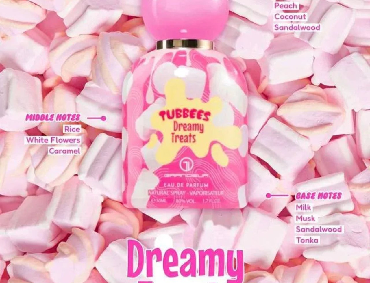 Grandeur Dreamy Treats Tubbees For Her 50ml — Pink perfume bottle with white and pink swirls, surrounded by marshmallows. Notes listed: Top (Lily of the Valley, Peach, Coconut, Sandalwood), Middle (Rice, White Flowers, Caramel), Base (Milk, Musk, Sandalwood, Tonka).