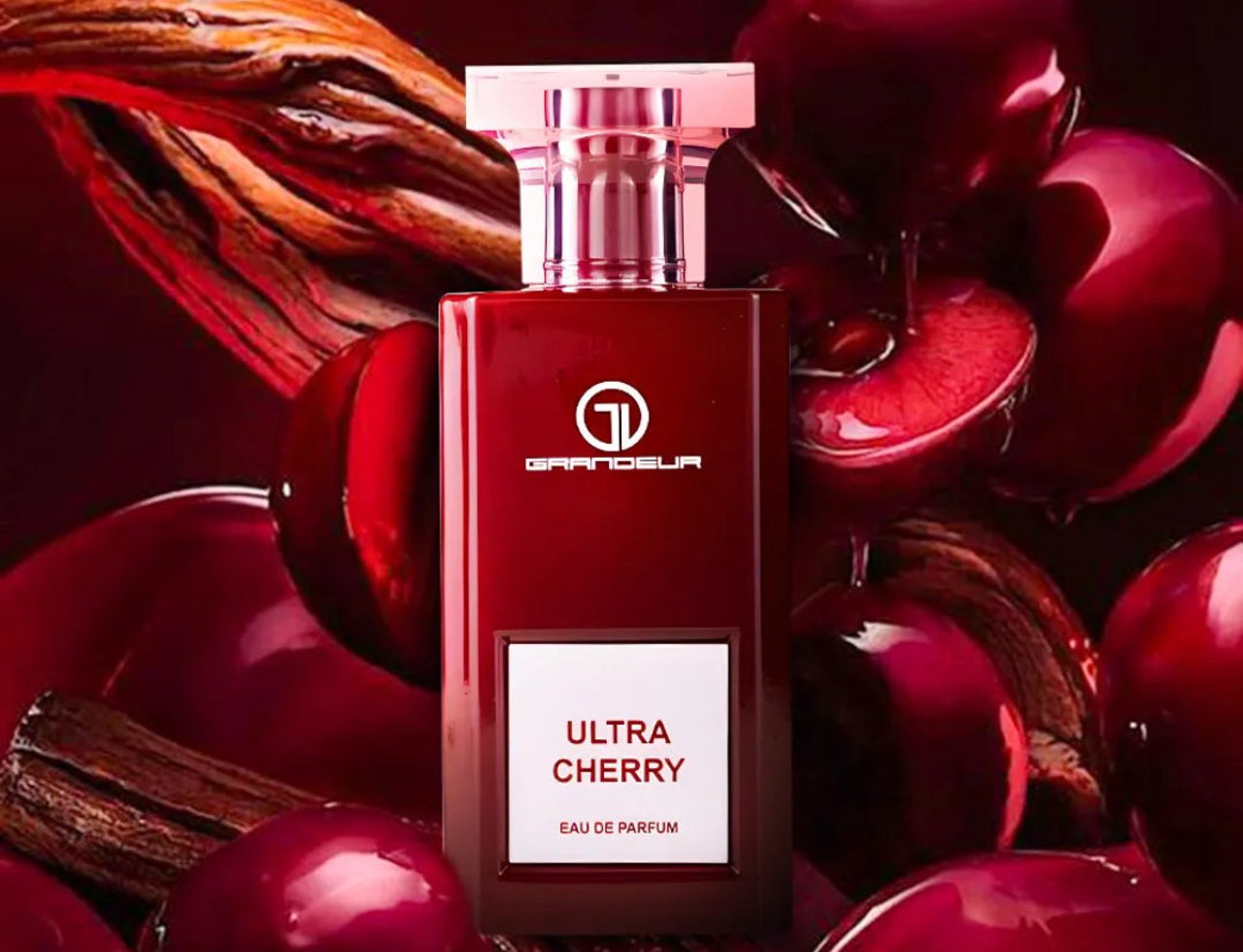 Grandeur Ultra Cherry by Grandeur – 100 ml for Women, a deep red perfume bottle surrounded by glossy cherries and wood elements.
