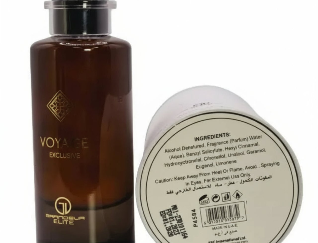 Grandeur Voyage Exclusif by Grandeur Elite – 100 ml untuk Lelaki, menampilkan botol kaca perang dan pembungkusan silinder putihnya dengan senarai ramuan.
