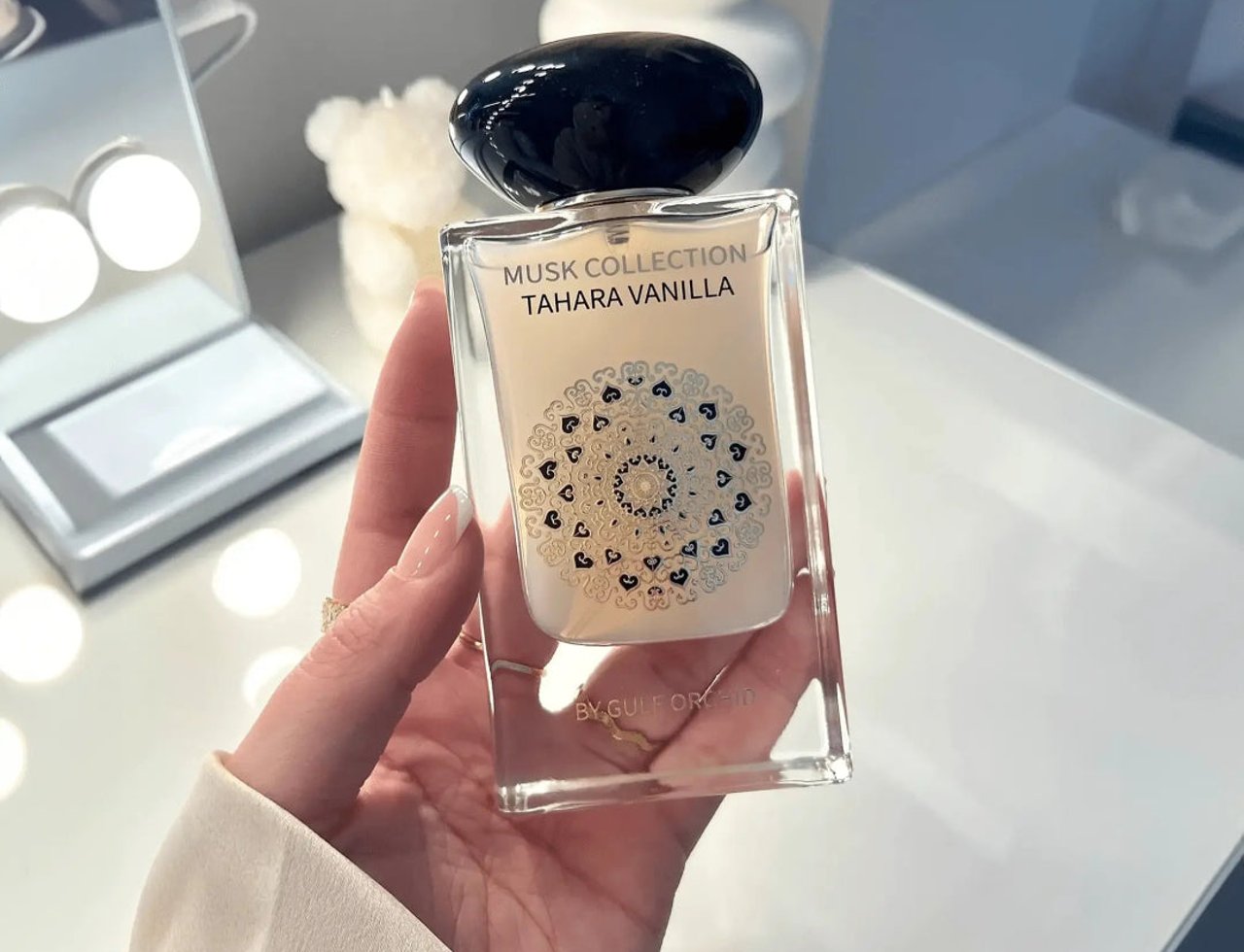 Gulf Orchid Musk Tahara Vanilla 60ml Gulf Orchid Woman — Hand holding a clear glass perfume bottle with a black cap, featuring a mandala design on the label.