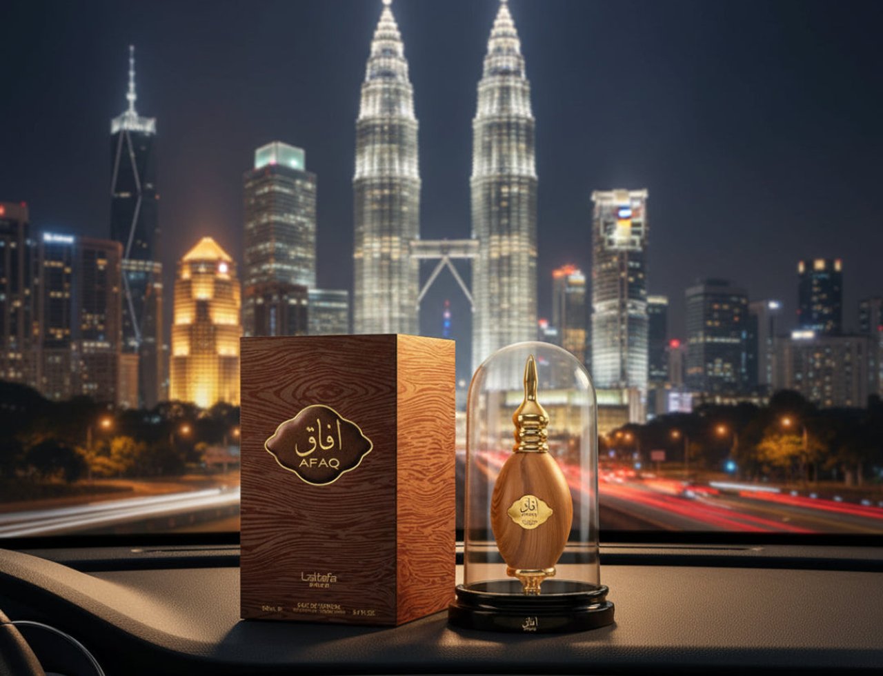 Lattafa Pride Afaq Gold by Lattafa EDP 100 ml Unisex — Kotak wangian bertekstur kayu dan botol emas berkubah kaca di atas papan pemuka kereta, latar belakang bandar KL waktu malam