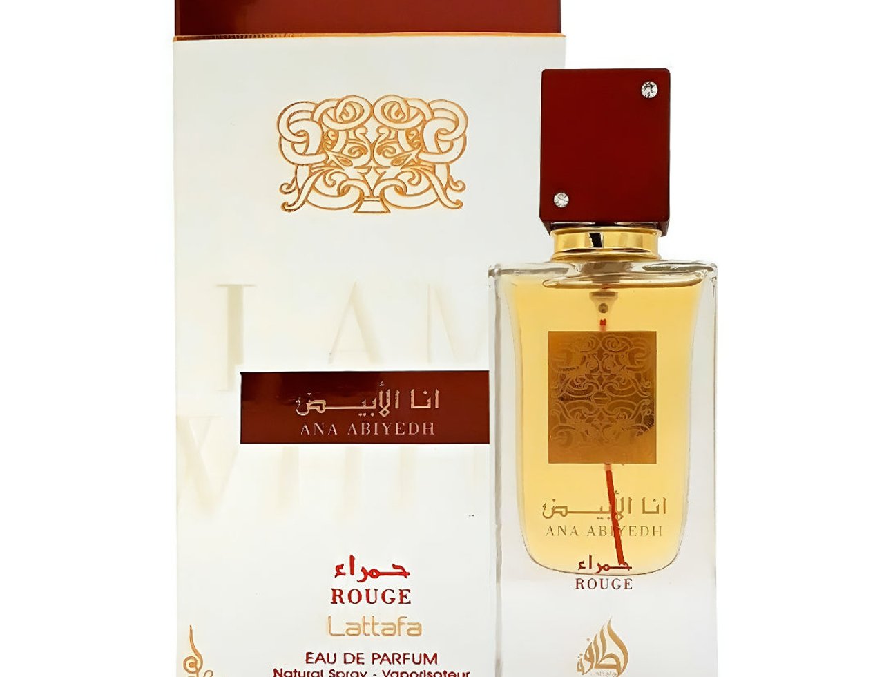 Lattafa Ana Abiyedh Rouge — White box with gold ornate design and red accents next to a clear glass perfume bottle with red