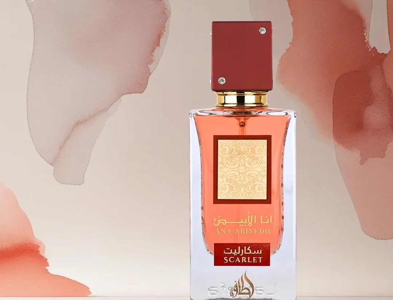 Lattafa Ana Abiyedh Scarlet by Lattafa 60ml EDP Women — Botol kaca jernih berisi cecair oren kemerahan, dengan penutup merah gelap dan perincian emas. Latar belakang abstrak warna pastel.