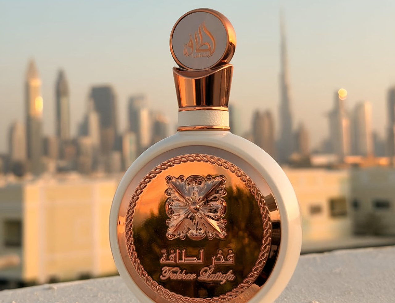 Lattafa Fakhar Rose Gold by Lattafa 100ml Women — White and rose gold perfume bottle with ornate emblem, Dubai skyline