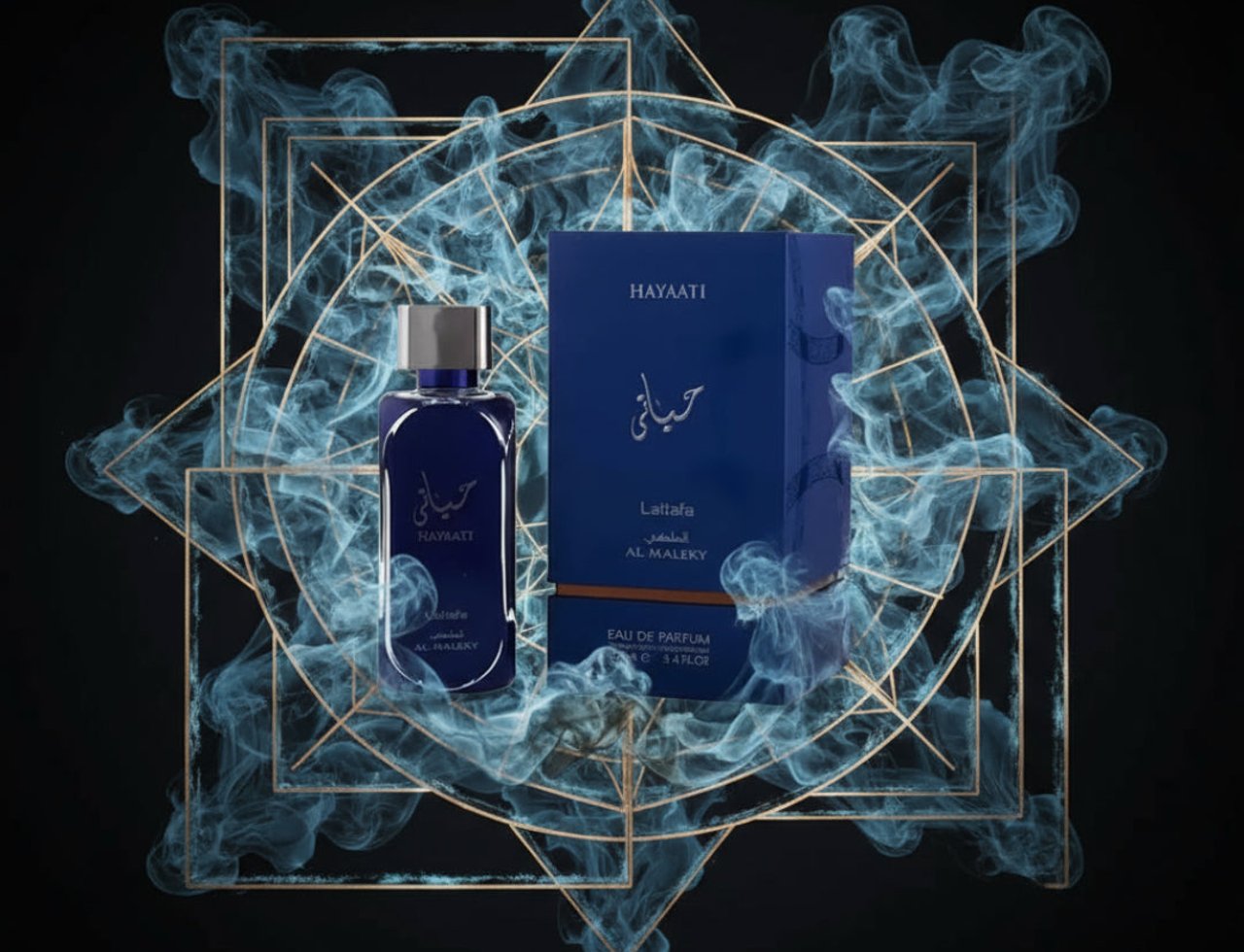 Lattafa Hayaati Al Maleky by Lattafa – 100 ml for Men, presented in a dark blue glass bottle with a silver cap, next to its matching dark blue box, surrounded by ethereal blue smoke and a geometric gold frame.