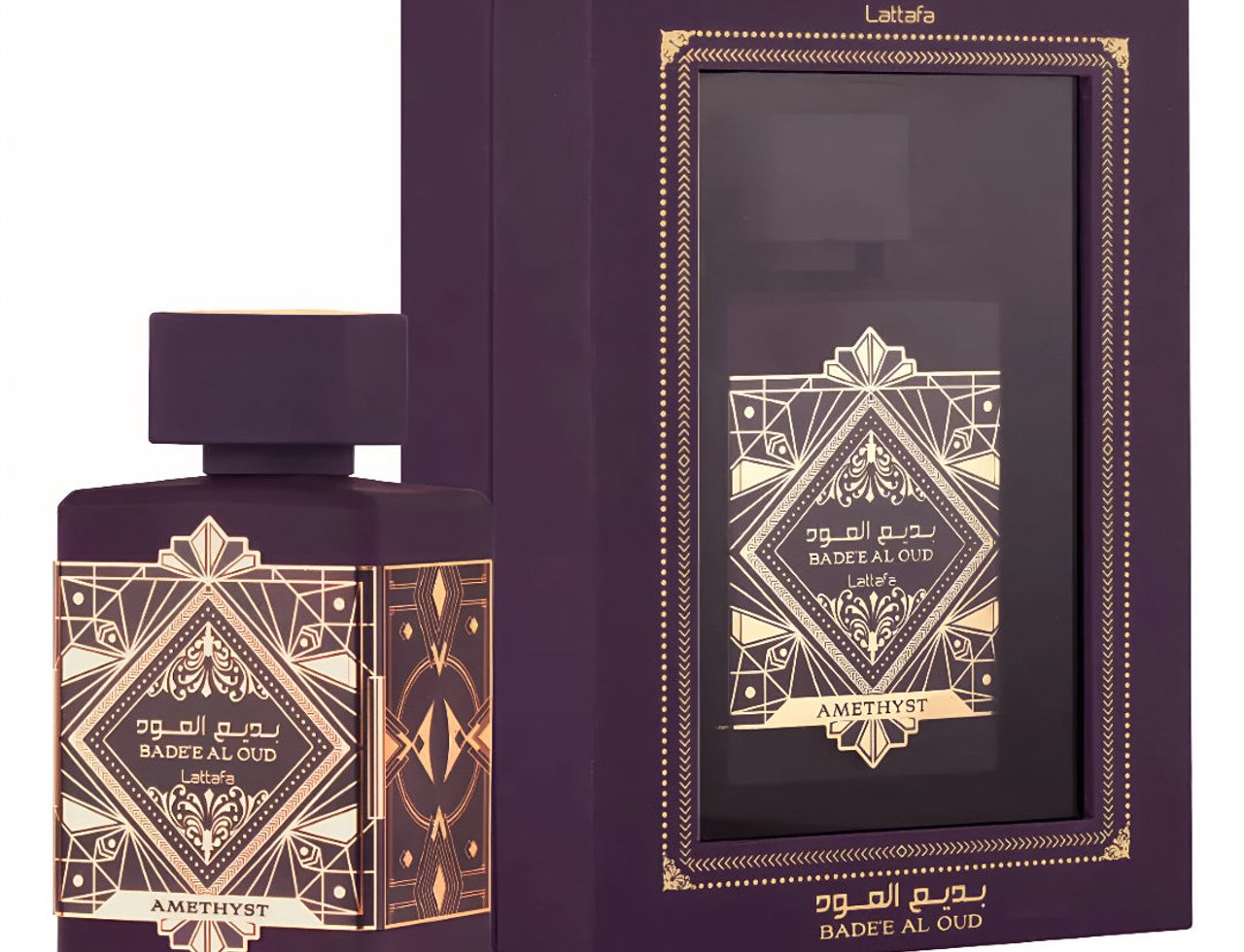 Lattafa Badee Al Oud Amethyst — Botol dan kotak wangian ungu gelap dengan reka bentuk geometri emas, penutup botol emas berkilat.