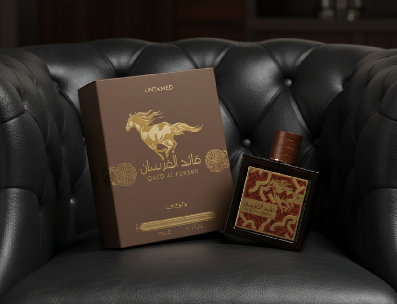 Lattafa Qaed Al Fursan Untamed Lattafa 90ml EDP — Kotak coklat dengan grafik kuda emas dan botol berlabel perhiasan di atas kerusi kulit hitam beropol.