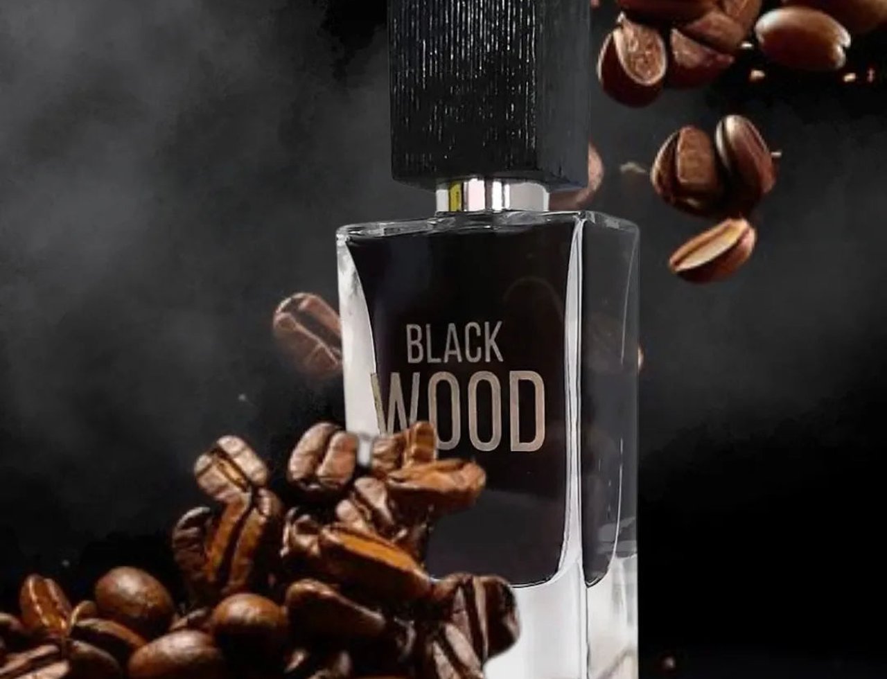 Maison Alhambra Black Wood 60ml EDP for Men — A black glass perfume bottle with a textured black cap, surrounded by scattered coffee beans and wisps of smoke against a dark background.