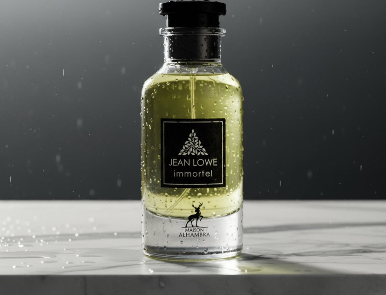 Maison Alhambra Jean Lowe Immortel by Maison Alhambra 100ml EDP Men — Botol minyak wangi kaca berisi cecair kuning, penuh titisan air, di atas permukaan marmar dengan percikan air, latar belakang gelap.