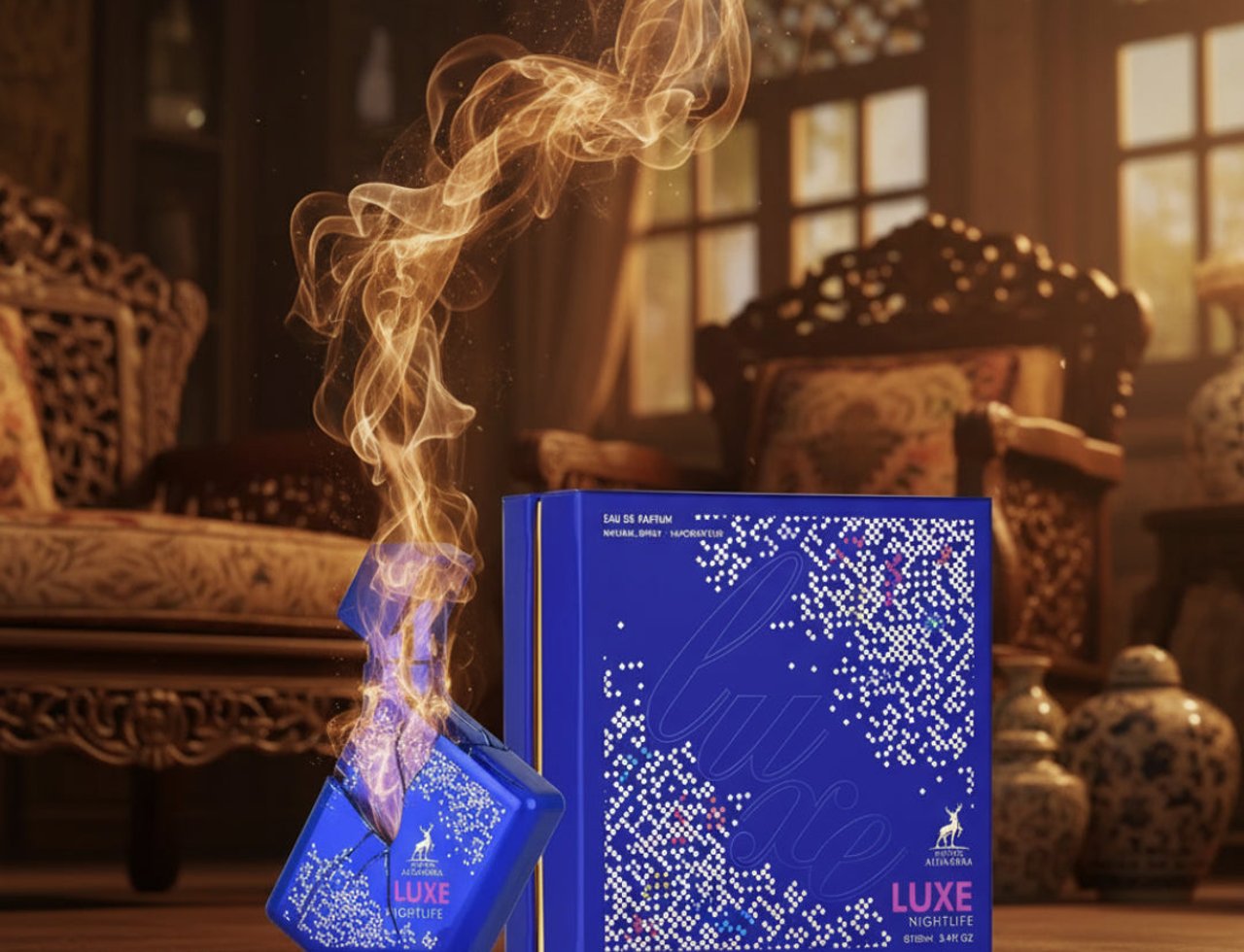 Maison Alhambra Luxe Nightlife — Botol minyak wangi biru retak dengan api keemasan meletus daripadanya, bersebelahan kotak birunya yang sepadan, berlatar belakang dalaman mewah.