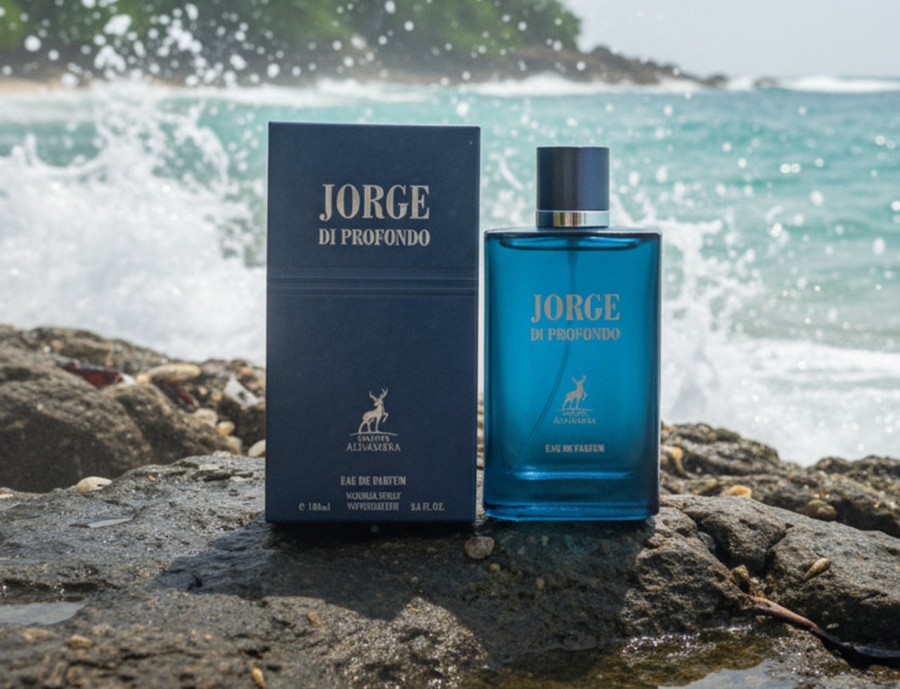 Maison Alhambra Jorge Di Profondo Deep Blue by Maison Alhambra 100ml Men — Blue glass perfume bottle and navy box on wet rocks with ocean waves crashing in the background.