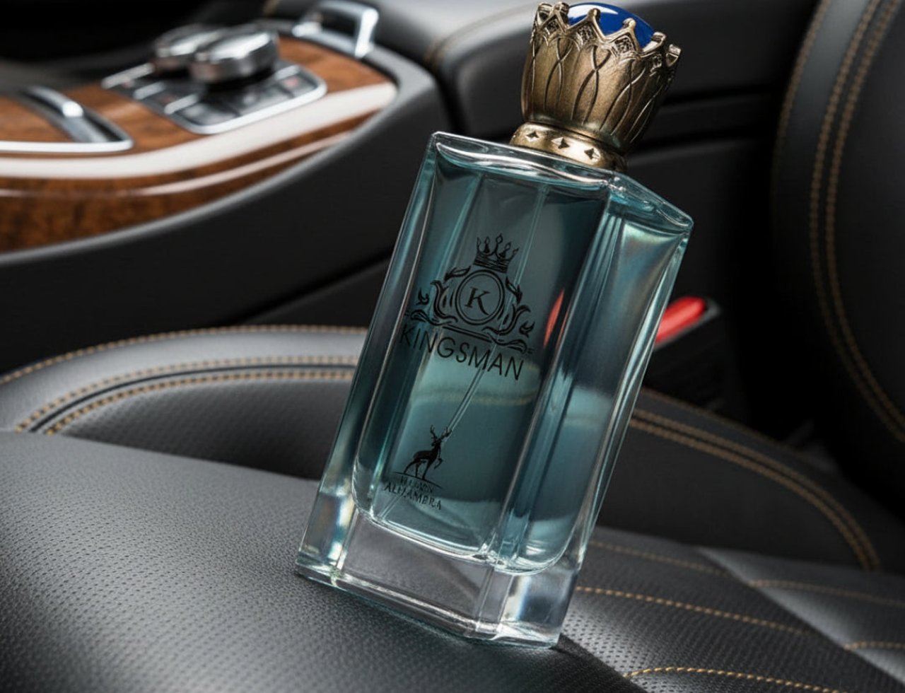 Botol wangian Maison Alhambra Kingsman by Maison Alhambra – 100 ml for Him dengan penutup mahkota emas berhias, diletakkan di atas tempat duduk kereta kulit hitam.