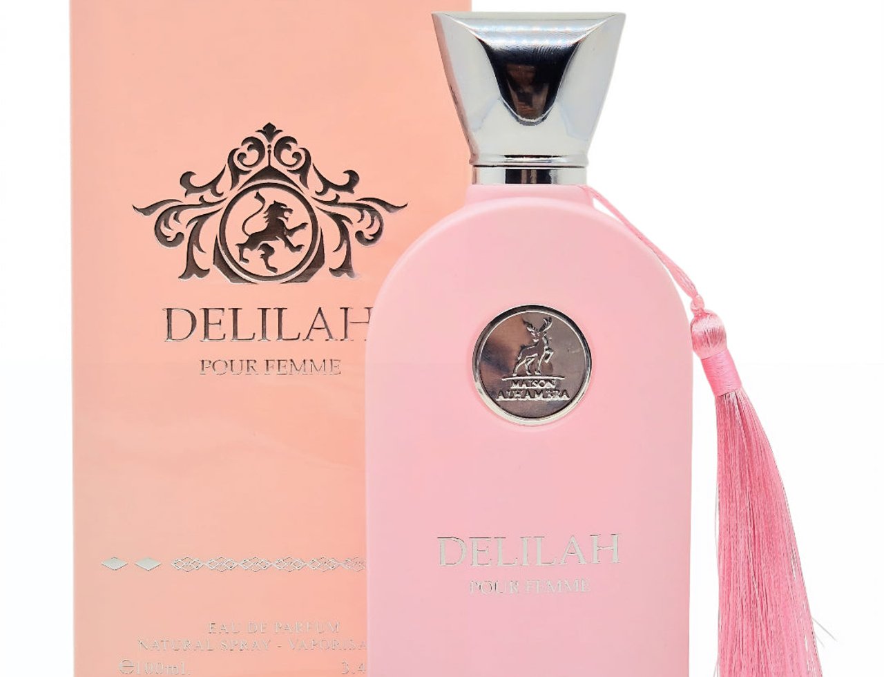 Maison Alhambra Delilah Pour Femme EDP 100ml – Women’s Perfume, pink bottle with silver cap and pink tassel, alongside its matching pink box with ornate lion emblem.