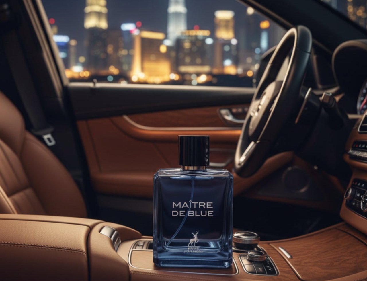 Maison Alhambra Maitre De Blue by Maison Alhambra 100ml for Men — Botol minyak wangi kaca biru bertutup hitam dengan logo rusa diletakkan di konsol tengah kereta mewah pada waktu malam, dengan latar belakang langit bandar yang kabur.