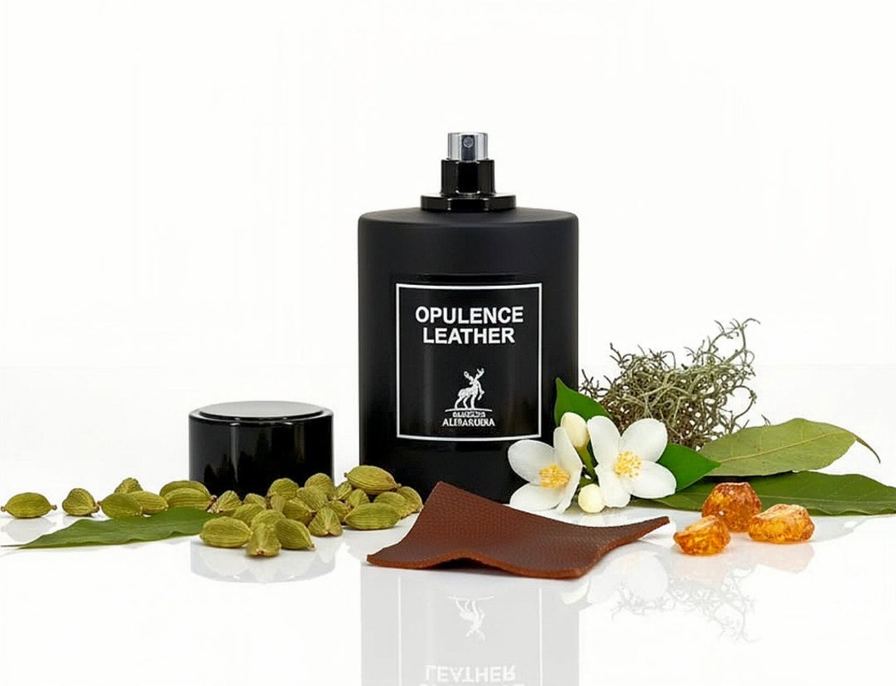 Maison Alhambra Opulence Leather — Botol minyak wangi hitam dengan penutupnya, dikelilingi buah pelaga, bunga melur, daun salam, resin amber, dan sehelai kulit.