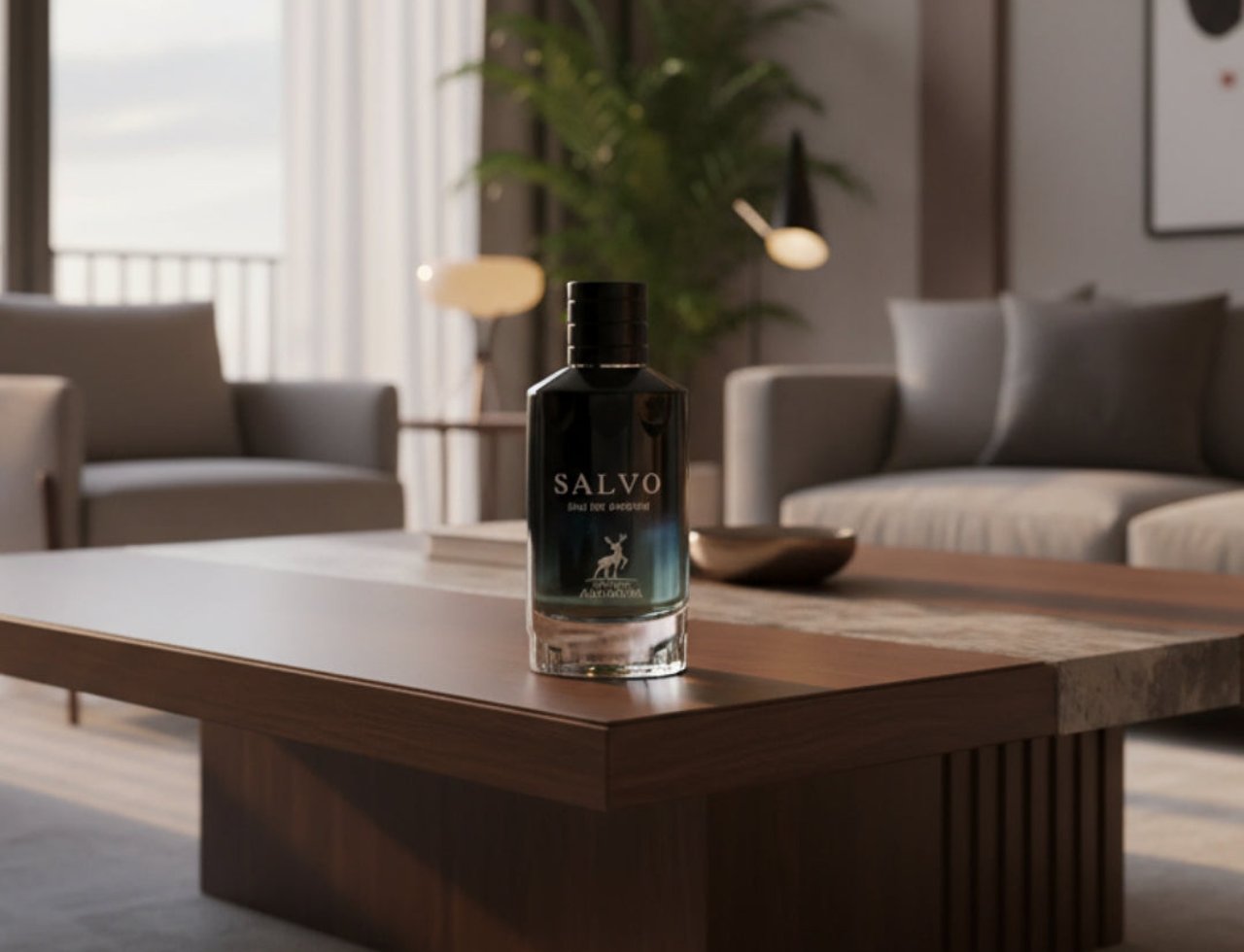 Maison Alhambra Salvo by Maison Alhambra For Him 100ml — A dark glass perfume bottle with a teal gradient label featuring a deer silhouette, placed on a wooden coffee table in a modern living room.