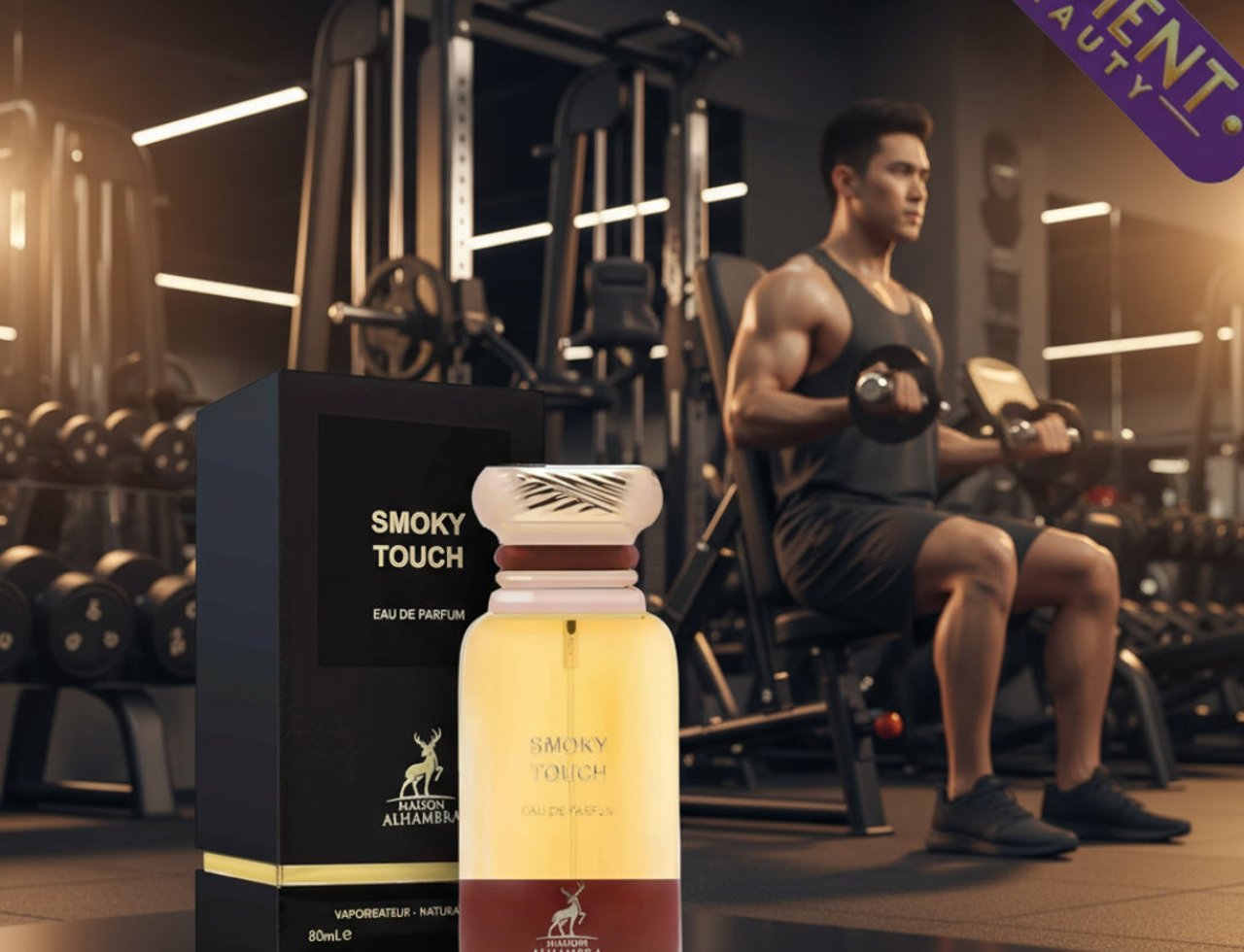 Maison Alhambra Smoky Touch 80ml EDP — Botol Eau de Parfum Smoky Touch oleh Maison Alhambra berdiri di sebelah kotak hitamnya dalam suasana gim, dengan seorang lelaki mengangkat berat di latar belakang.