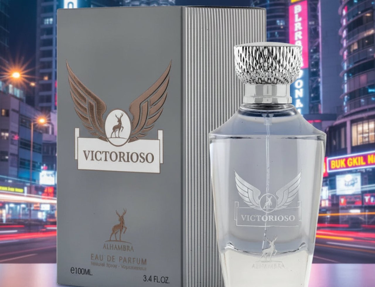 Maison Alhambra Victorioso by Maison Alhambra 100ml EDP Men — Grey box and clear glass bottle with silver cap, featuring winged deer logo, set against a blurred city night background with traffic light trails.